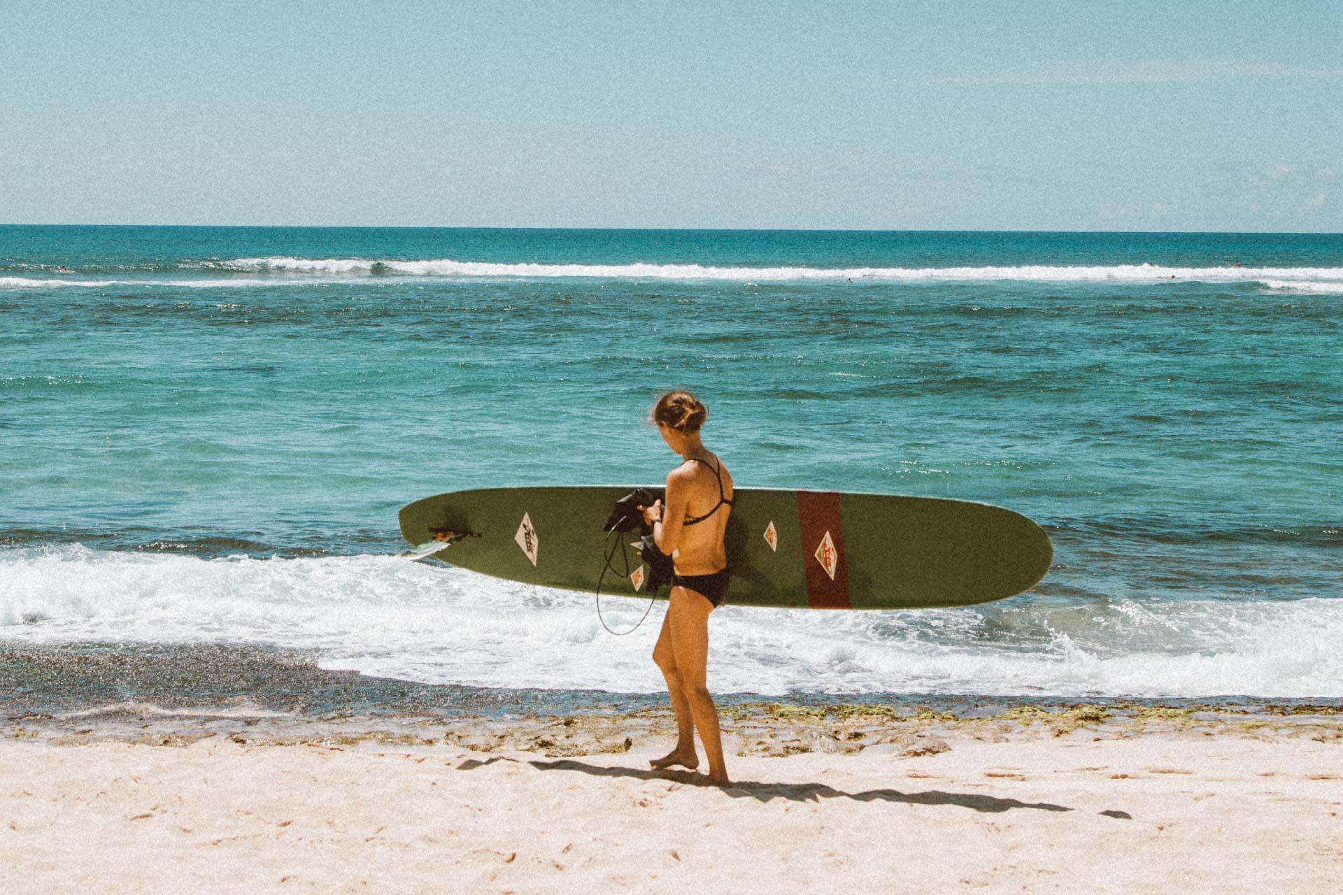 mujer-con-tabla-de-surf-en-playa-de-hawai